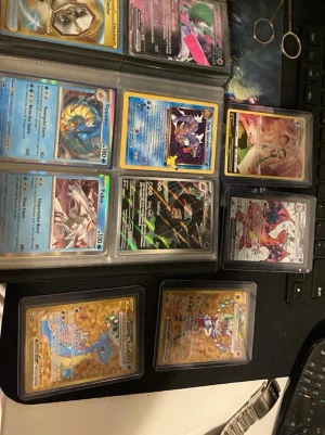 Pokémonkort samling med holo och GX- kom med bud - Stor samling Pokémonkort med flera holo, GX och VMAX-kort. Innehåller bland annat Charizard, Lapras och Gyarados i guld- och regnbågsglans. Korten är i plastfickor och hårda sleeves. Perfekt för samlare eller dig som vill boosta din lek med snygga och sällsynta kort.