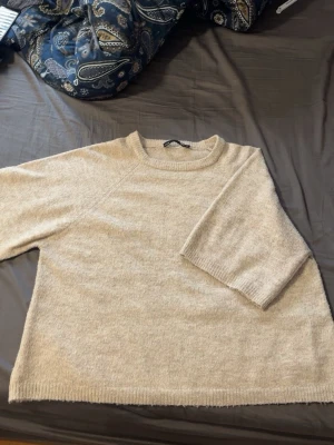 Beige stickad tröja från Lager 157 - Mysig beige stickad tröja från Lager 157 med rund halsringning och trekvartsärmar. Storlek S