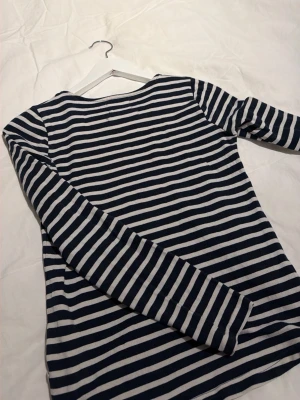 Randig långärmad topp Holly & Whyte🤍 - Säljer en långärmad topp från Holly & Whyte by Lindex med marinblå och vita ränder. Toppen har en klassisk rund halsringning med en gul kantdetalj. Pris kan diskuteras💞💞
