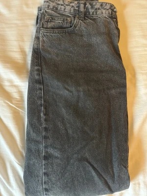 Svarta raka jeans från GANT - Snygga svarta jeans från GANT i klassisk rak modell. Jeansen har fem fickor, bälteshällor och en svart läderpatch med GANT-logga bak i midjan. Materialet är kraftig denim i bomull med en tvättad look.