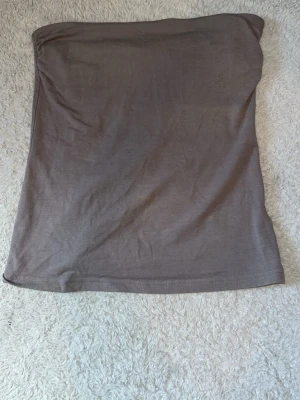 Brun tubtopp i bomull - Snygg brun tubtopp i mjukt bomullsmaterial. Enkel och stilren design utan axelband, perfekt för lager på lager eller till varma dagar. Lätt rynkning upptill för bättre passform.