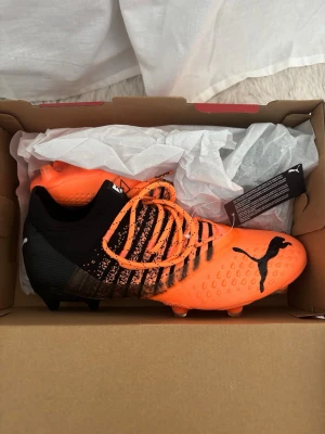 Puma Future - Helt nya med etikett - Säljer ett par Puma Future i orange färg. Skorna är helt nya och aldrig använda, etikett sitter kvar.  Modell: Puma Future Storlek: 42,5   Skick: Nytt   Färg: Orange    Nypris ca 1500 kr.  Perfekta för dig som vill ha riktigt bra fotbollsskor till ett bra pris!  Pris: 1199 kr (kan diskuteras vid snabb affär)