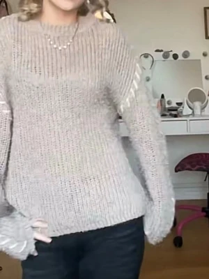Beige stickad tröja med ribbade detaljer - Mysig beige stickad tröja med ribbade muddar och rund hals. Tröjan har en avslappnad passform och långa ärmar. Perfekt för lager på lager och enkel att matcha med olika stilar. Den är ganska nopprig. Storlek xs/s. Den är beige/brun/grå typ