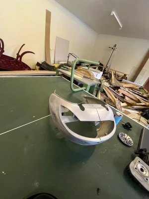 Främre kåpa till moped eller scooter - Säljer en silverfärgad främre kåpa i plast, troligen till moped eller scooter. Kåpan har stora öppningar för strålkastare och ventilation samt fästen för montering. Passar dig som behöver reservdel till ditt fordon.