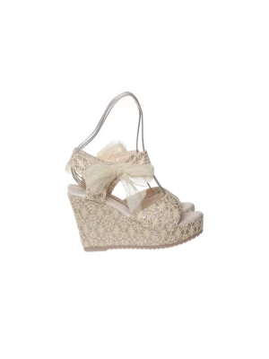 Beige kilklackade spets-sandaler - Snygga sandaler med kilklack i beige spets och transparenta detaljer. Dekorerade med stora rosetter i organza och öppen tå. Perfekta för dig som vill ha en romantisk och unik look. Klacken är täckt med spetsmönster och remmarna är tunna och eleganta.