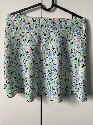 Blommig kortkjol i pastellfärger - En jätte fin grön kjol från ginatricot. Jätte skönt satin material som även är väldigt stretchigt vilket gör att den passar flertal storlekar. Bara använd några gånger och i jättebra skick. Perfekt nu till sommaren. 🌸🌺🩷