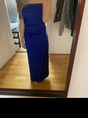 Blå axelbandslös långklänning - Säljer nu min fina balklänning som är fixad och sydd hos skräddare. Satin material och öppen rygg. Slits där bak!! Jag är ca 165 som referens💗💗