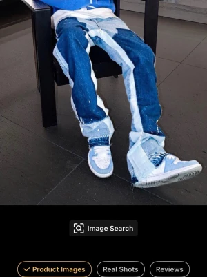 Patchwork jeans med breda ben - Unika patchwork jeans i blå denim med breda ben och kontrasterande ljusa och mörka paneler. Jeansen har råa kanter, synliga sömmar och en avslappnad passform som ger en trendig streetwear-look. Perfekta för dig som vill sticka ut med din stil.