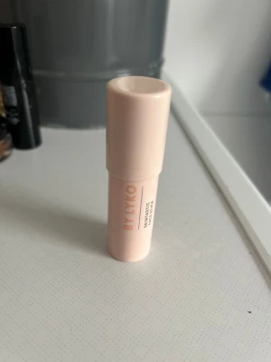 By Lyko Majestic Highlight Stick - Highlighter i stickformat från By Lyko i färgen Sandy Glow. Kommer i en ljusbeige, rund plastförpackning som är smidig att använda direkt på huden. Ger ett snyggt glow och är enkel att ta med i väskan tack vare sin kompakta storlek.