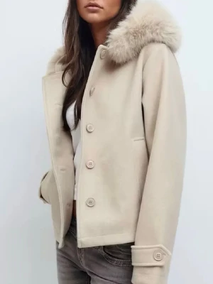 Beige kappa med fuskpäls - Stilren beige kappa med stor krage i mjuk fuskpäls och knäppning framtill. Kappan har raka ärmar med dekorativa manschetter och två sidofickor. Perfekt för dig som vill ha en klassisk men trendig look. Materialet ser ut att vara ullmix. Använd endast en gång