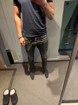 Replay jeans  - Säljer ett par svarta slim fit jeans med klassisk femficksdesign och låg midja. Jeansen har en snygg tvättad look och smal passform som sitter tajt längs benen. Perfekta för dig som gillar en modern och stilren stil.
