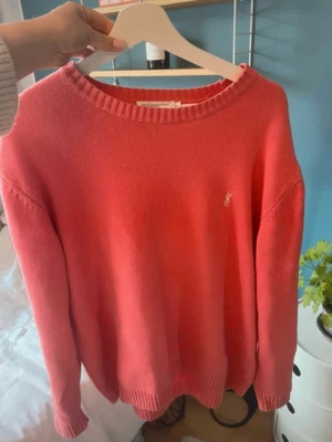 Vintage stickad YSL-tröja - Snygg ros stickad tröja från Yves Saint Laurent med broderad YSL-logga på bröstet. Tröjan har rund halsringning, ribbade muddar och är tillverkad i 100% bomull. 