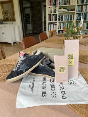 Golden Goose svarta blå/svart mocka - Hej! Säljer dessa feta golden goose i mocka perfekta till sommaren✨|Storlek 44| Har lite slitage vid hälen (se bilderna). 100% äkta. Äktighetsintyg finns genom QR koden. Box och dustbag ingår🤩Har lite slitage vid hälen (se bilderna). Förutom det är de i bra skick! Hör av dig vid frågor. Pris diskuterbart 🙌
