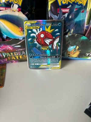Pokémonkort Magikarp & Wailord GX - Säljer ett Pokémonkort med Magikarp & Wailord GX Tag Team. Kortet har en färgglad och glansig design med blå, röd och gul färg. Perfekt för samlare eller dig som vill boosta din lek med en cool och unik GX-kort.