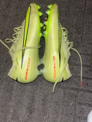 Nike Mercurial vapor elite AG - Säljer ett par Nike Mercurial fotbollsskor i ljusgul färg med svarta och neonorange. Sulan har fasta dobbar för spel på konstgräs men fungerar även utmärkt på naturgräs. Perfekta för dig som vill sticka ut på planen! Orginalpris 3300, lägre pris kan diskuteras. Skorna är i mycket bra skick och har ej några funktionsnedsättningar som påverkar spelet negativt. Använt dessa på endast 5 tillfällen. Köpta på Unisport, kartongen finns även med.
