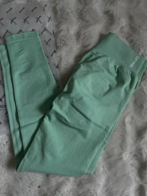 Turkosa Dfyne !  - Sitter som s/ m men är m Säljer ett par mintgröna seamless leggings från Dfyne. De har hög midja och ribbad linning för extra stöd. Materialet är stretchigt och mjukt, perfekt för träning eller chill. Snygg scrunch-detalj bak för en schysst passform.