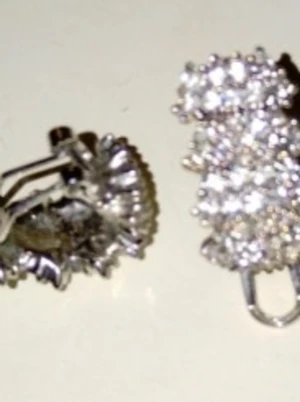 Glittriga silver clipsörhängen - Säljer ett par glittriga silver clipsörhängen med massor av små gnistrande stenar i kluster. Örhängena har en vintagekänsla och med stenar som ger en lyxig look. Perfekta för dig som vill sticka ut med accessoarerna.