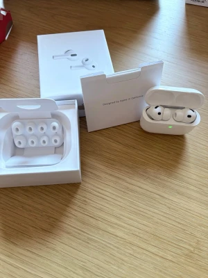 Apple AirPods Pro gen 3 i nytt skick - Säljer ett par vita Apple AirPods Pro med laddningsetui och extra silikontoppar. Hörlurarna är trådlösa in-ear-modell med stilren design i plast och silikon. Perfekta för musik, samtal och träning. Levereras med originalförpackning och tillbehör.