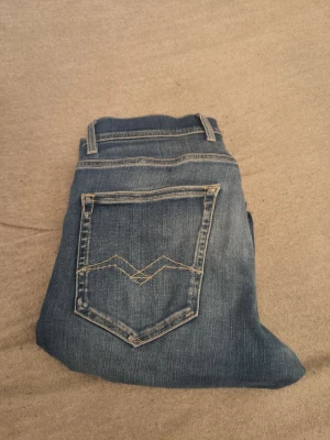 Blå jeans med kontrastsömmar - Snygga blå jeans med klassisk femficksdesign och kontrastsömmar på bakfickorna. Jeansen har normal midja, bälteshällor och raka ben. Perfekta för en avslappnad och trendig look.