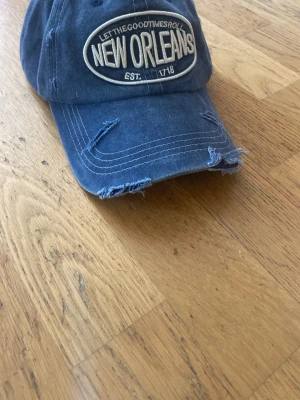 Blå keps med New Orleans logga. - Snygg blå keps som nästan är helt ny. Går att byta storleken på den. 