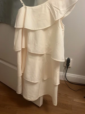 Off shoulder klänning från Gina Tricot - Snygg off shoulder klänning från Gina Tricot i ljus gulfärg. Klänningen har volang och är en axel. Använd en gång, strycker innan jag skickar iväg