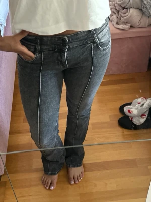 Svarta bootcut jeans med kontrastsömmar - Snygga svarta bootcut jeans med vita kontrastsömmar och klassisk femficksdesign. Jeansen har en något utsvängd passform nertill och normal midja. Perfekta till en avslappnad stil och lätta att matcha med olika toppar. Sönder i ena bält fickan som ni ser på bilden, är man bra med nål och tråd är det enkelt att fixa, nypris 400kr men pågrund av hålet säljs de för 95kr