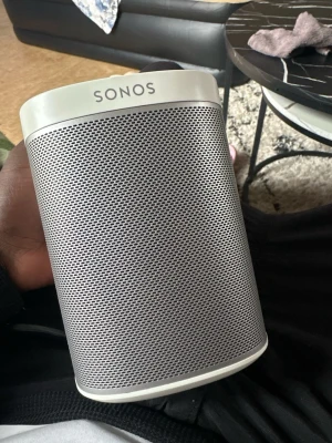 Sonos vit trådlös högtalare - Snygg och stilren trådlös högtalare från Sonos i vit färg. Högtalaren har en rundad, kompakt design med metallgaller framtill och plastdetaljer. Perfekt för att streama musik trådlöst hemma med riktigt bra ljudkvalitet.