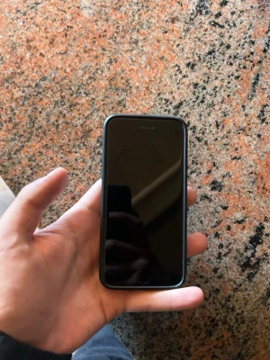 iPhone med färgglatt skal - Säljer en iPhone med svart framsida och ett unikt, färgglatt skal med tecknade motiv och graffiti-inspirerad design. Telefonen har rundade hörn och klassisk Apple-design i glas och metall. Perfekt för dig som vill sticka ut med din mobil. (Du behöver bara factory reset igenom din dator)