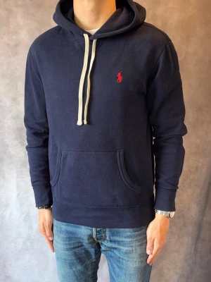 Marinblå Ralph Lauren Hoodie - Stl M - Riktig fet hoodie från Ralph Lauren 🙌| Mycket bra skick: 9,2/10, utan defekter  | Stl: M |  Modellen är 177cm och väger 74kg | Billigare pris vid köp av bundle 😉Hör av dig vid frågor // Galgen 🫡 