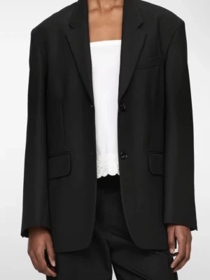 Svart oversized kavaj från H&M - Stilren svart kavaj från H&M i oversized modell med klassiska slag och två knappar framtill. Kavajen har två fickor med lock och en bröstficka. Materialet är slätt och ger ett snyggt fall. Perfekt för att skapa en cool och trendig look.