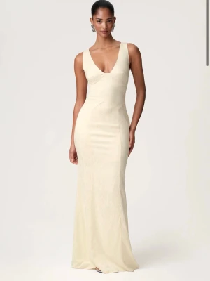 Ljus gul långklänning med knytband. Perfekt för bal. - Ordinarie pris 1595 kr. Elegant ljus långklänning med djup v-ringning och smala axelband som knyts i rosetter på ryggen. Klänningen har en figurnära passform och är tillverkad i ett mjukt, lätt material som ger ett lyxigt intryck. Perfekt för speciella tillfällen som till exempel bal. Endast använd en gång.