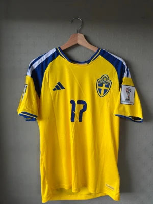 Sverige vm tröja Gyökeres - Gul svensk landslagströja från Adidas med blå detaljer och Gyökeres vi nummer 17 på bröstet. Riktigt stilren och fräsch inför sommaren. 