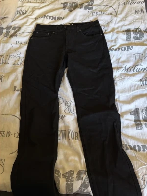 Svarta raka jeans från 157 - Säljer ett par svarta jeans från 157 med rak passform och klassisk femficksdesign. Jeansen har bälteshällor och knappgylf. 
