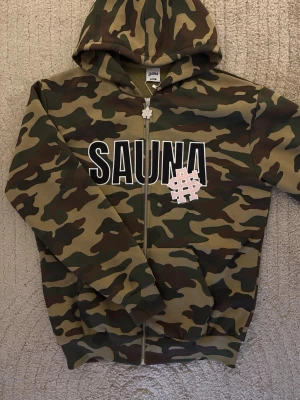 SAUNA hoodie - ny med tags - SAUNA är ett danskt high fashion streetwear märke. Säljer denna hoodie då den tyvärr är för liten. Endast provad, alla tags och lappar sitter kvar. Nytt skick. Säljs billigt för snabb affär inför flytt