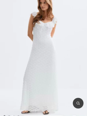 Vit klänning från Gina Tricot - Säljer denna helt nya klänning med spets och volangdetaljer från Gina Tricot. Kläningen är aldrig använd och har lapparna kvar. 🤍