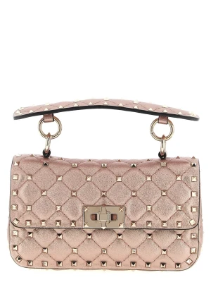 Rosa Valentino väska  - Stilren handväska i metallicrosa med quiltat mönster och guldfärgade nitar. Väskan har ett handtag upptill, kedjerem och vridlås i guld. Perfekt accessoar för dig som gillar edgy detaljer och trendig design.