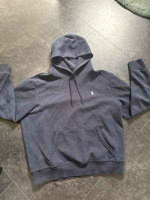 Polo Ralph Lauren Hoodie  - Snygg mörkblå hoodie. Färgen ser lite solbränd ut de är bara ljuset har inte andvänd den så mkt kan fixa bättre bilder ifall due intresserad. Nypris 2,4. Den passar ifall due mellan M-L kom med frågor och funderingar