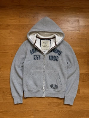 Abercrombie & Fitch 2000s men's hoodie Large - Abercrombie & Fitch Grå Hoodie - Vintage Y2K - Märkt XL (passar L) Snygg och eftertraktad Abercrombie & Fitch hoodie från 2000-talet i grå färg. En klassisk Y2K-modell med hög kvalitet och tidlös design - perfekt för dig som gillar vintage. Märke: Abercrombie & Fitch Färg: Gra Märkt storlek: XL Passform: Passar bättre som L eftersom det är en äldre modell. Skick: Bra vintage-skick (se bilder för detaljer). Skickas snabbt och säkert. Hör gärna av dig om du har några frågor eller vill ha fler bild