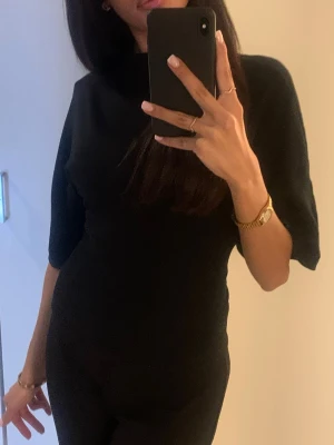 En svart tröja från Gina med en öppen rygg som man knyter med ett band - En svart tröja från Gina med en öppen rygg som man knyter där bak nästa helt ny använt ett par gånger så snygg till en utekväll eller bara generellt 