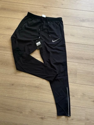 Nike running - Säljer ett par svarta Nike running byxor. Har aldrig använt de. Byxorna har en extra ficka där bak. Strl S för junior 