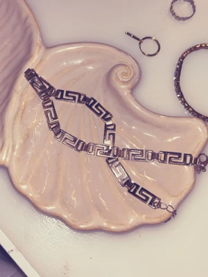 Silverfärgat armband - Snyggt armband i silverfärgad metall med klassiskt grekiskt nyckelmönster. Länkarna är rektangulära och armbandet har ett smidigt lås med extra kedja för justerbar längd. Perfekt för dig som gillar stilrena accessoarer. Gå in på mitt konto jag säljer FLERA smycken i olika former och färger. 😊 