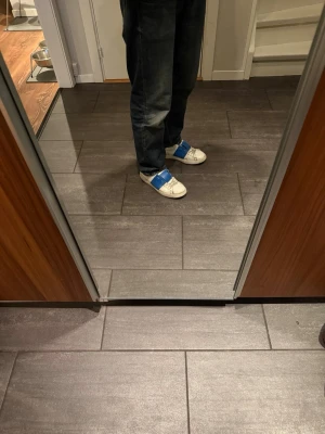Vita sneakers med blåa kardborreband - Valentino skor, storlek 43. Dem är i bra skick o kan användas ett bra tag till. Har även lämnat in till en skomakare som har fixat upp dem lite.     ÄKTA