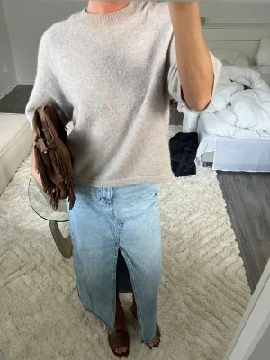 Ljusblå lång jeanskjol med slits - Trendig ljusblå lång jeanskjol i klassisk denim med hög midja och en snygg slits framtill. Kjolen har en rak passform och rå kant nertill för en avslappnad vibe. Perfekt att styla med en stickad tröja eller t-shirt.