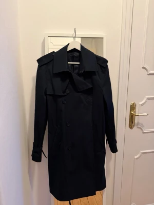 Mango trenchcoat - Mörkblå trenchcoat från mango, sitter som lång s / medium. Använd ca 1 gång