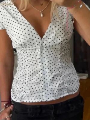 Prickig topp urban outfitters - Säljer en svartvit prickig topp/blus från Urban outfitters. Storlek S/M. Sitter bra på mig som vanligtvis har S/M. Lika fin till vardags som till fest:) första bilden är lånad, andra är min.