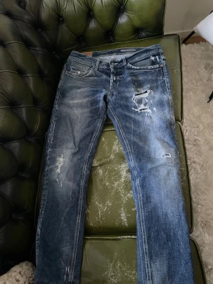 Dondup George. - Säljer ett par dondup med slitningar och hål på låret och knät. Jeansen har raka ben och en fet tvätt. Passar bra till alla situationer.