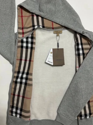 Burrberry Zip Up - Säljer en snygg Burberry Zip Hoodie i nästan ny skick 9.5/10✅Tröjan är storlek L men passar M✅Lapparna medföljer ej pga tappat bort dem🤗Hör av er vid frågor och funderingar🤩🤝