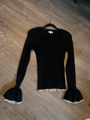 Svart tröja med trumpetärmar - Superfin svart tröja med beiga detaljer och fin uringning och ärmar, köpt begagnad för 300kr 🩷