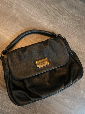 Svart handväska Marc by Marc Jacobs - Snygg svart Marc jacobs väska, vet ej om den är äkta men köpt på second hand för 700kr, saknas en del från märket 