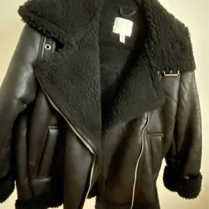 Pilotjacka från hm. Aldrig använd  - Snygg svart pilotjacka från H&M med bred krage och fuskpälsfoder. Jackan har dragkedja i silver, stora fickor och detaljer som spänne vid kragen. Perfekt för dig som vill ha en trendig och varm look. Storlek xs